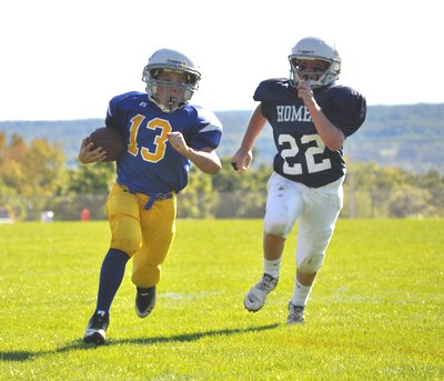 Lansing Bobcat Colin McClure (#13) scores his first touchdown of the 2011 football season as he outruns a Trojan defender. Photo by Michelle Eastman sff Colin23